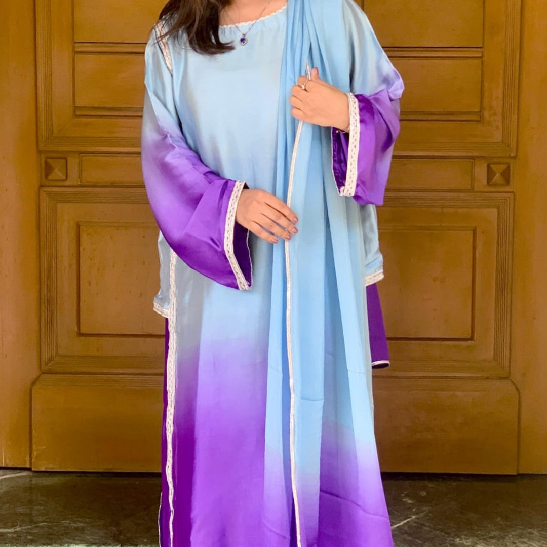 Person wearing a light blue and purple gradient dress against a wooden door background