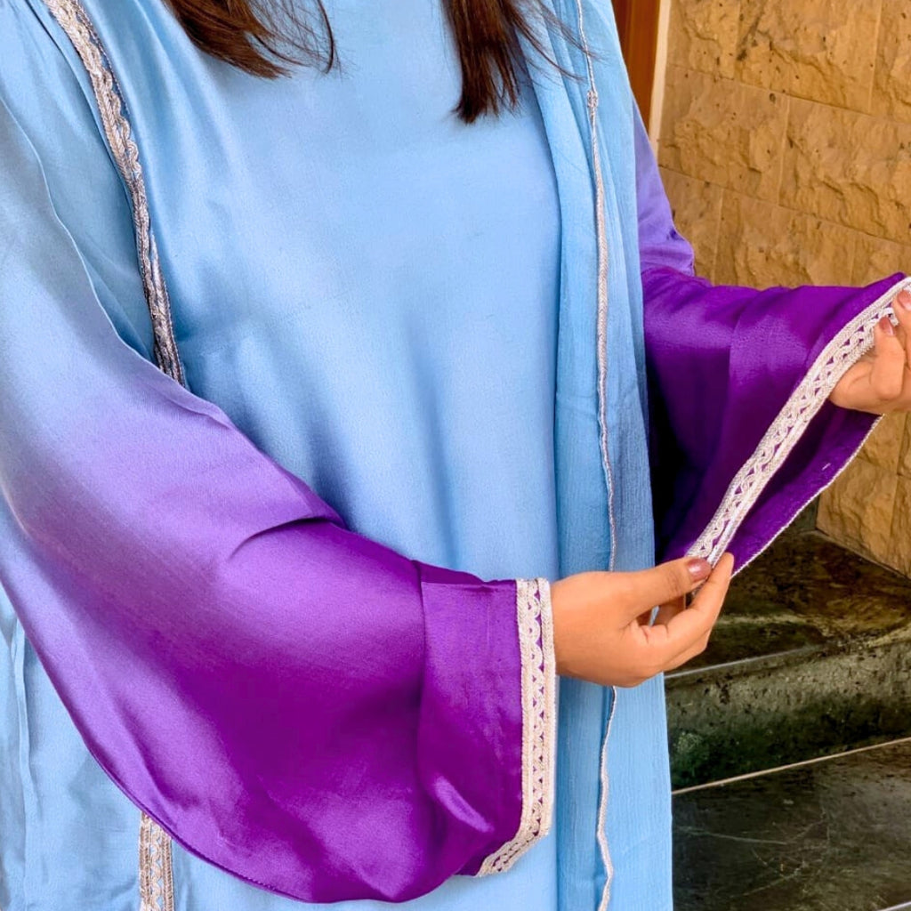 Light blue and purple garment with lace trim held by a person.