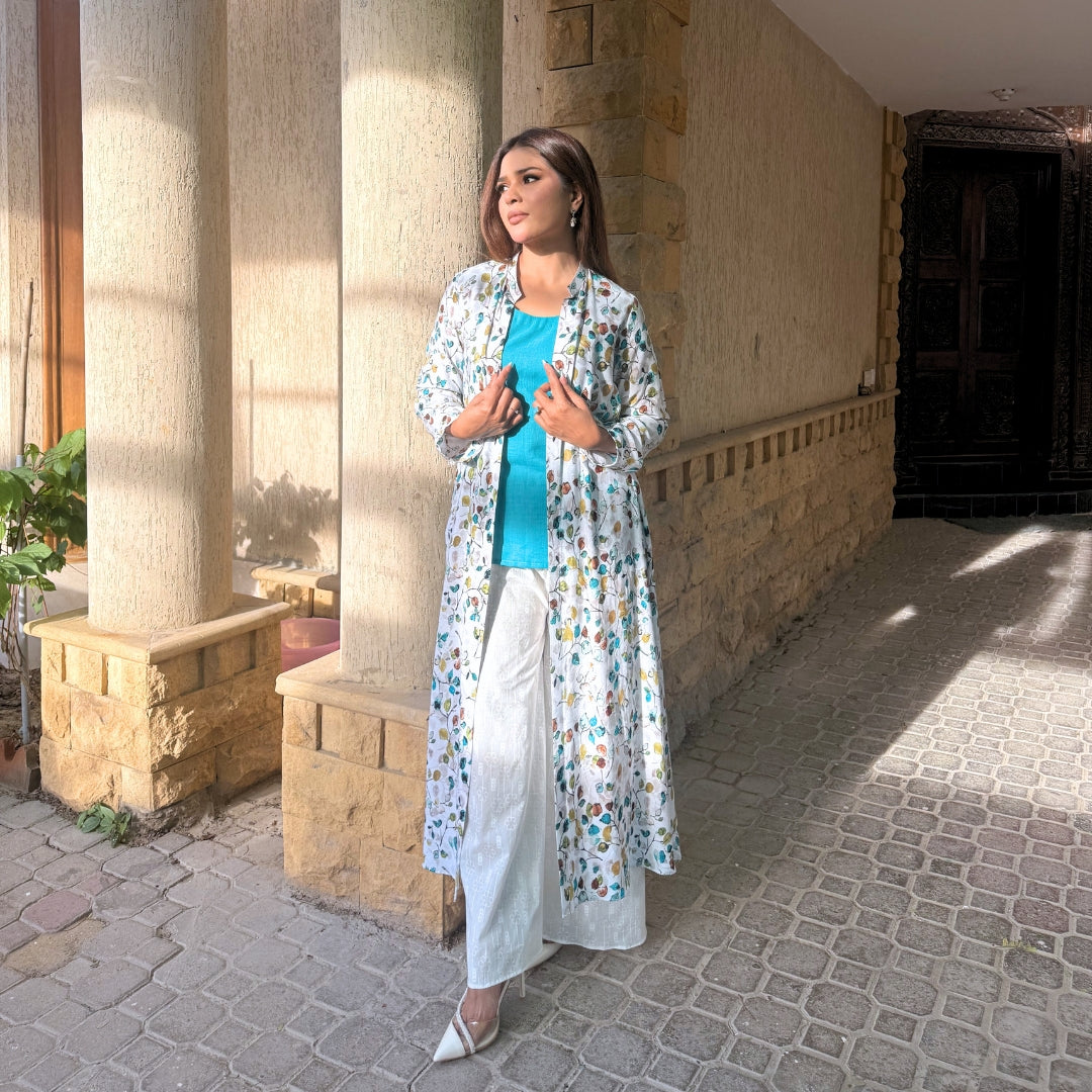 Woman in a floral outfit standing in front of a stone building