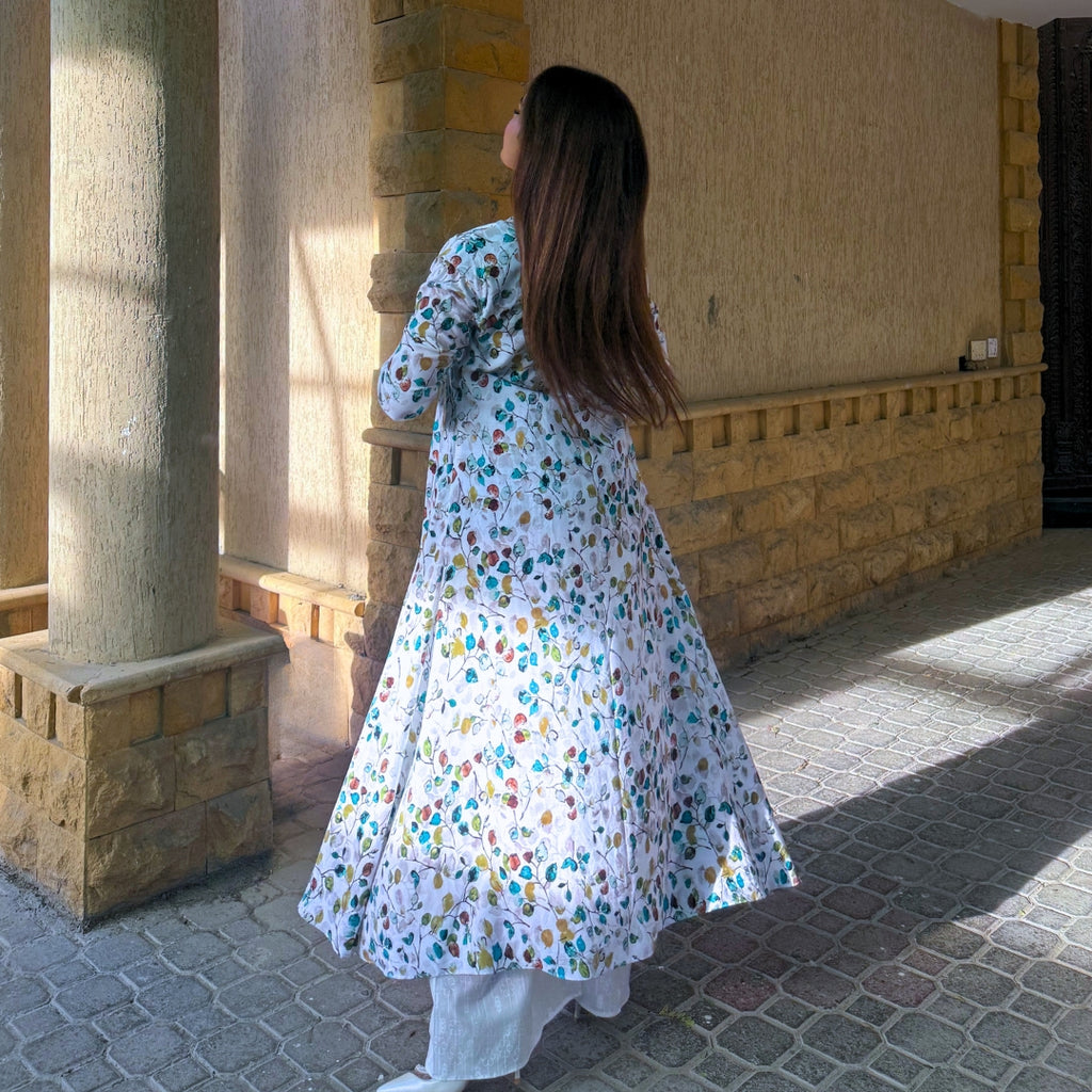Woman in a floral dress standing in front of a stone building