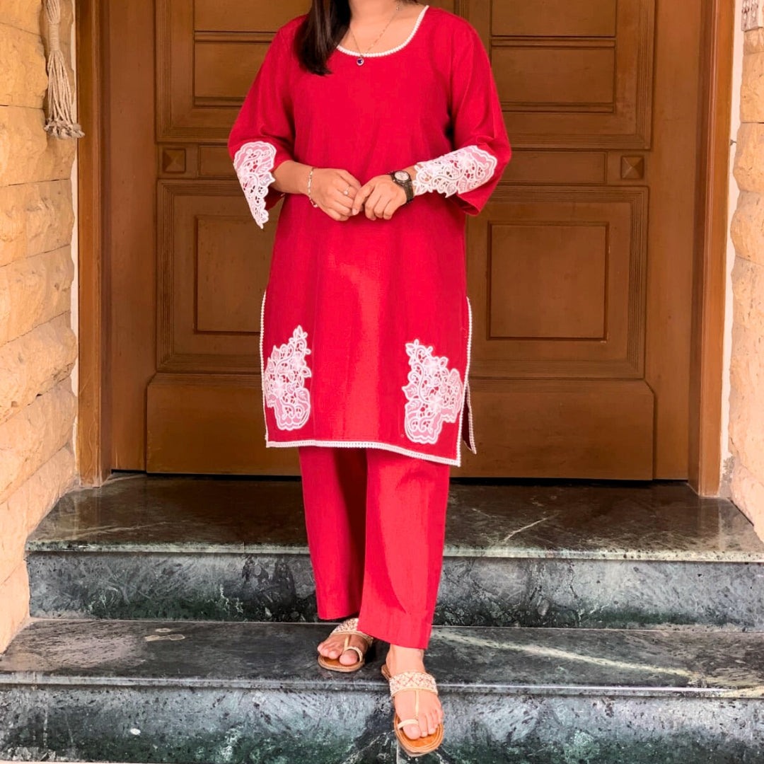 Female Person wearing a red outfit with white lace details standing on steps.